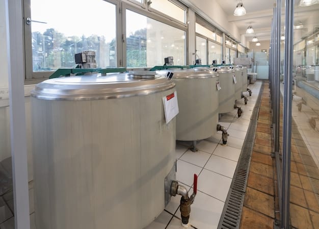 Interior of a modern water treatment facility with large, stainless steel tanks and complex piping systems. Technicians in hard hats are inspecting the equipment, ensuring the safe and efficient processing of water. The scene emphasizes cleanliness and technological advancement.