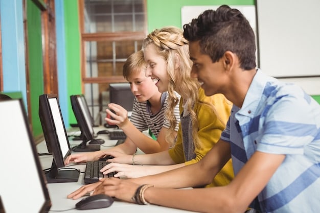 High school students using computers in a classroom setting, working together to learn coding techniques.